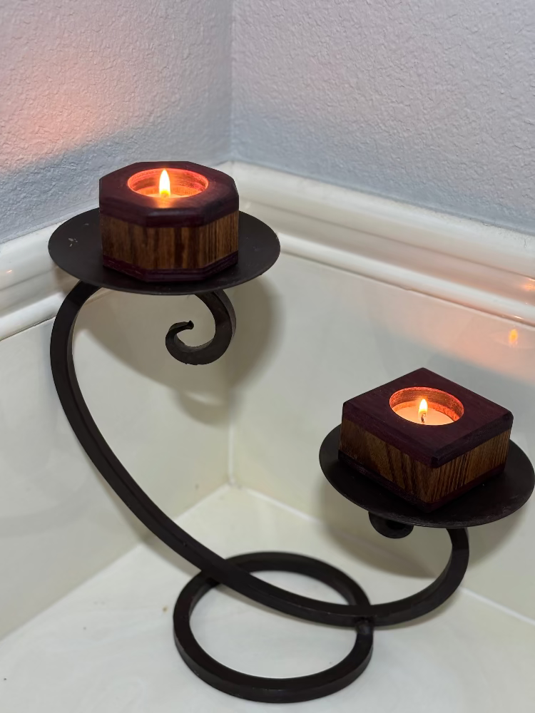 Decorative candle holder with two lit candles on a white surface.